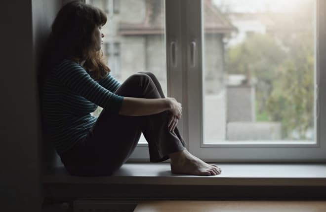 A woman sat looking out of a window. We are the foremost provider of barristers for sexual offences work in North Wales and into the North West.