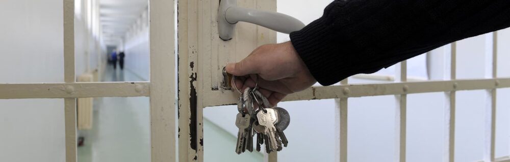 A person locking a prison door. The criminal team includes specialists with expertise in relation to prisons and parole boards including hearings and pre-tariff reviews.