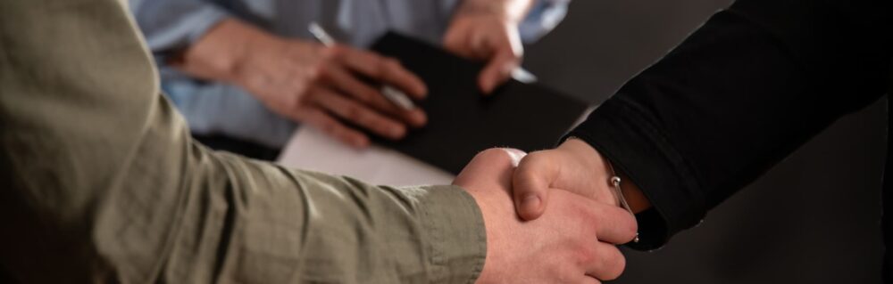 Two people shaking hands. Mediation and ADR is often used to help clients to reach an agreement whilst avoiding the formality of Court proceedings.